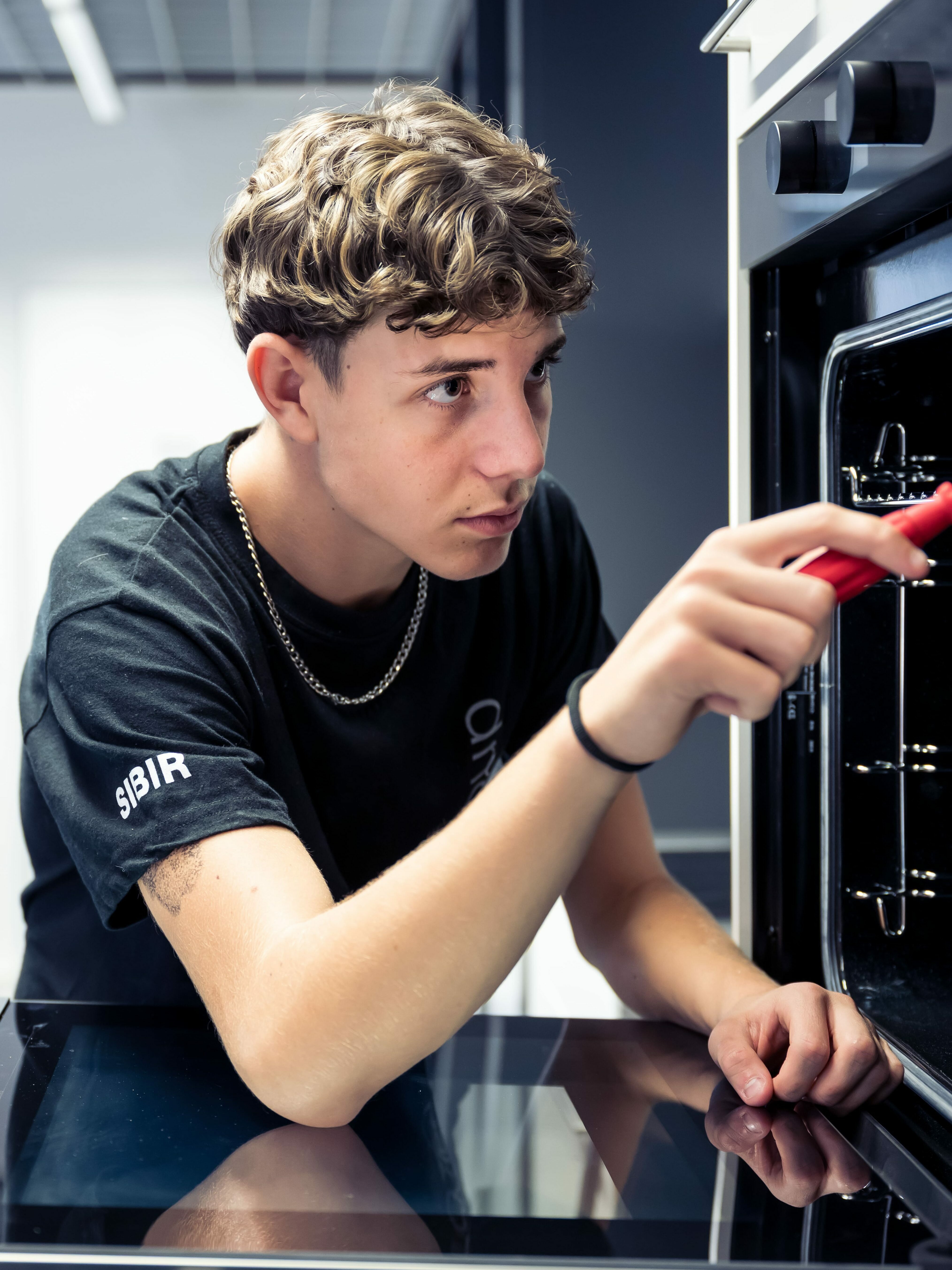 Lehrling am Backofen Schrauben