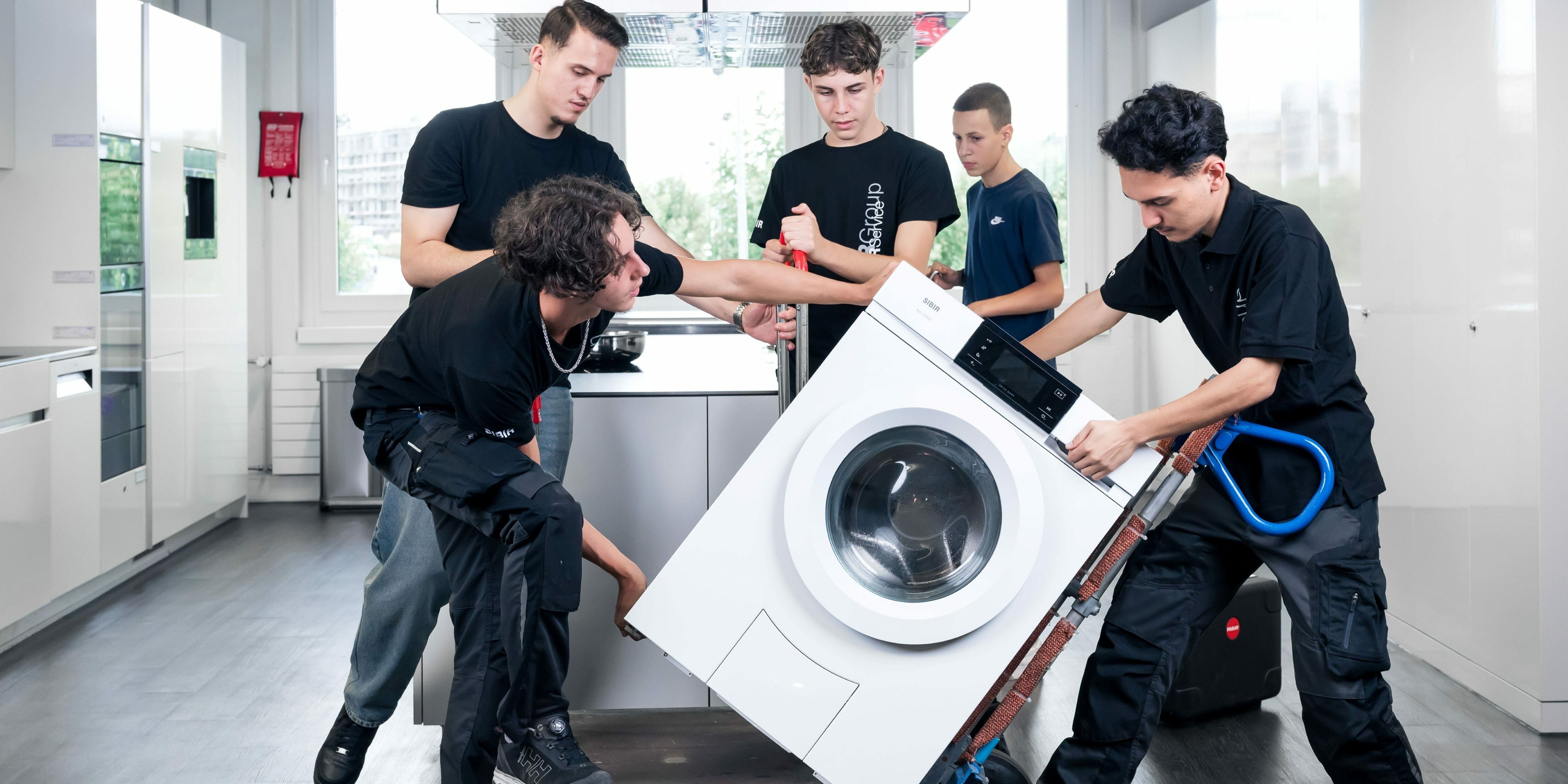 Gruppenfoto Lehrlinge mit Waschmaschine