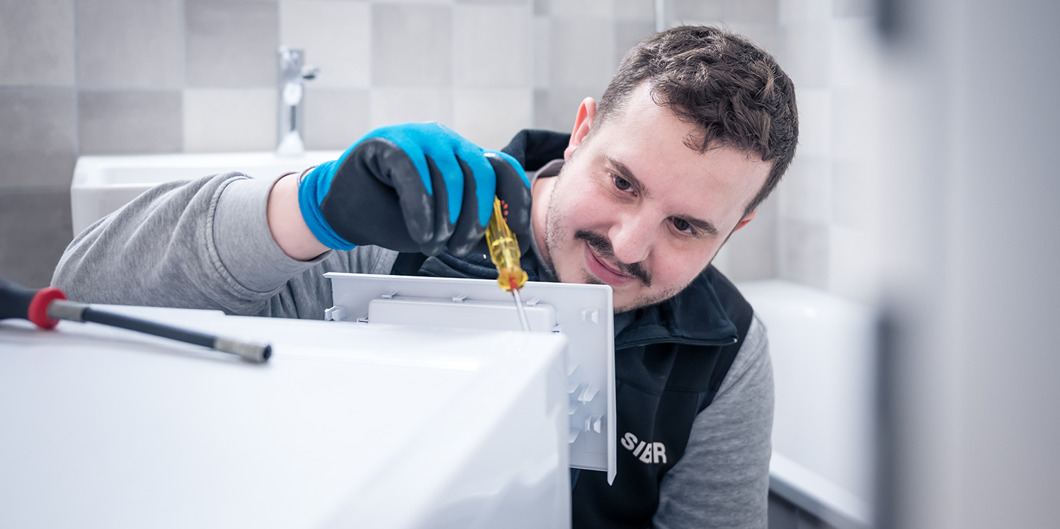 SIBIR Techniker repariert Waschmaschine