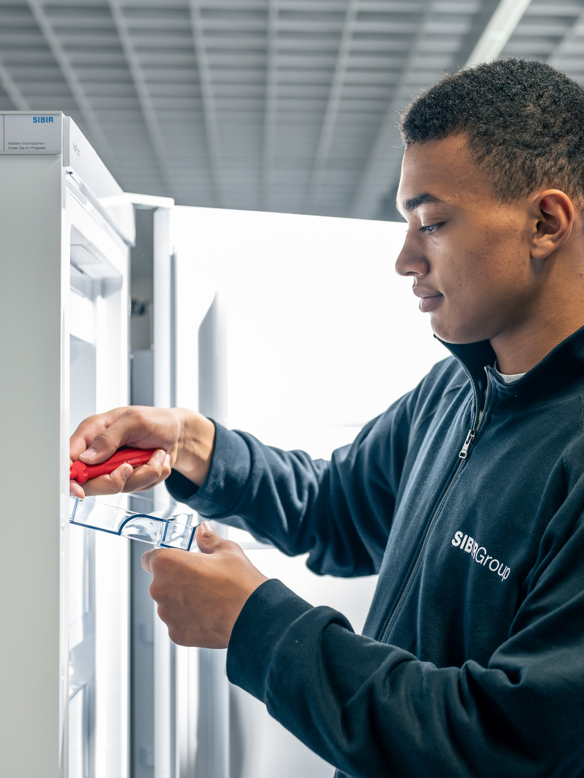 SIBIR technicien de service répare le compartiment du réfrigérateur