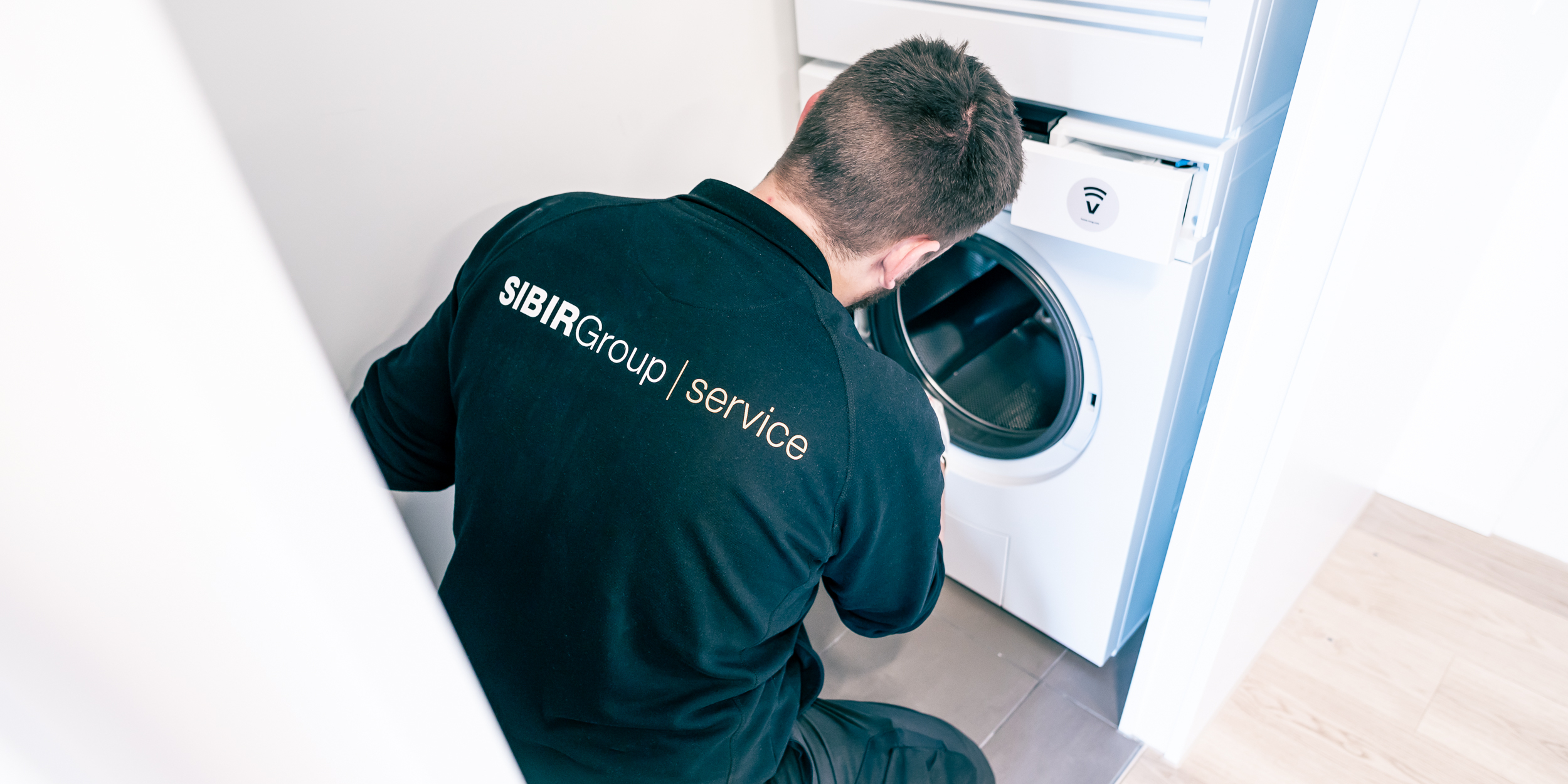 SIBIR technicien de service pendant l'installation d'une machine à laver
